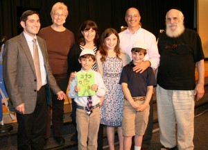 Caleb Peck (holding siddur) and family with Rabbi Jeffery Arnowitz. 