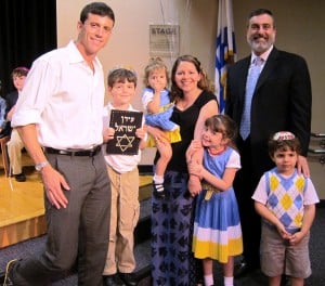 First grader Aiden Kempner (holding siddur) with his family an Rabbi Silver