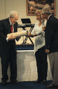 Dr. Pat Robertson accepts the scroll from Barbara and Ken Larson