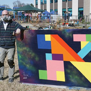 Hillel Smith with his mural for the ViBe District.