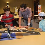 Third graders, Effie Blair and Ben Amitay, who shows his bridge project to Science Fair judge.