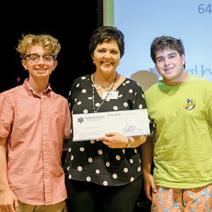 Danial Watts and Zach Sissel of the Emerging Philanthropists Council present a check for $500 to Kelly Burroughs, JFS CEO.