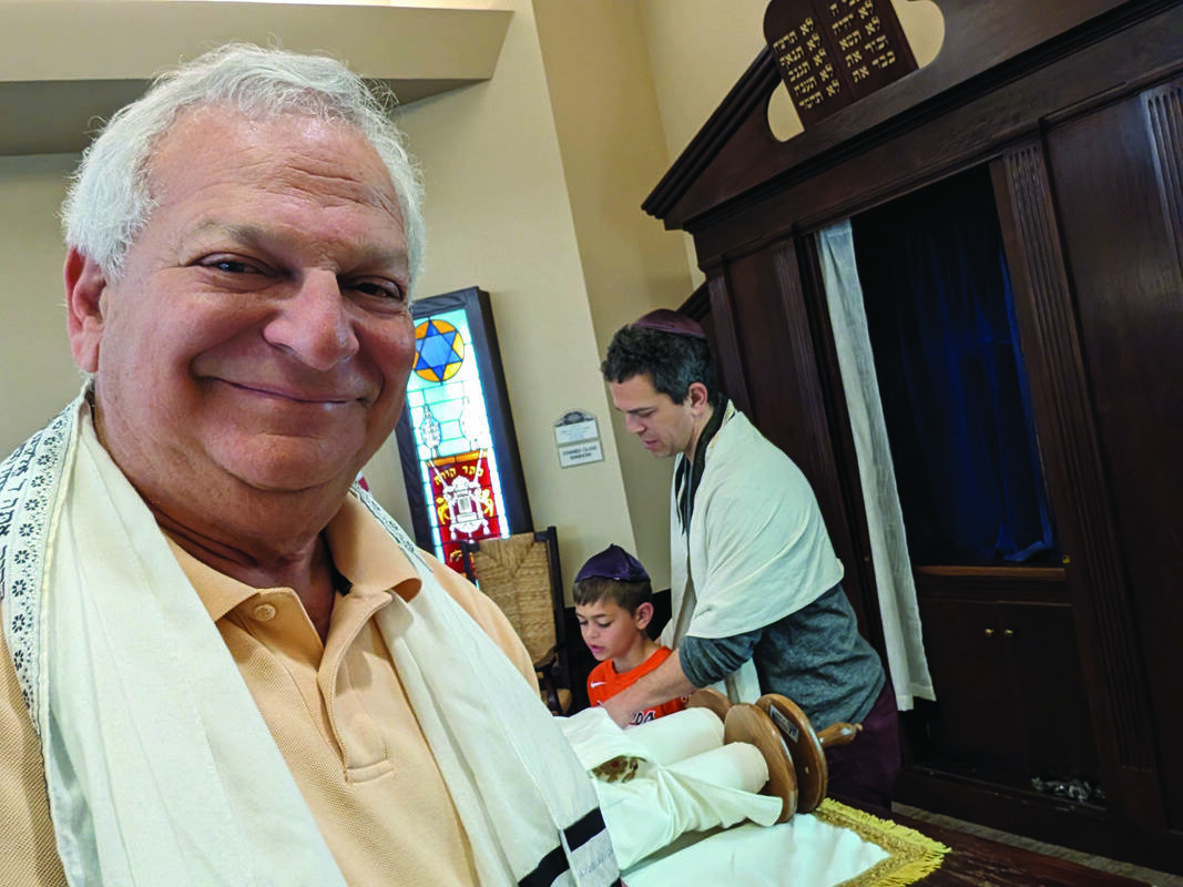 Joel Rubin stands in the foreground at Maimonides Health Center of Virginia Beach (formerly Beth Sholom Home) in April 2024. Behind him, Danny Rubin helps his son, Niv, with the prayers during a Saturday morning Shabbat service. L'dor v'dor.