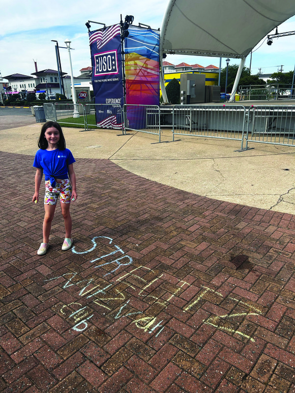 Lillian Mae before the beach cleanup with her drawing representing the SIA Mitzvah Club.