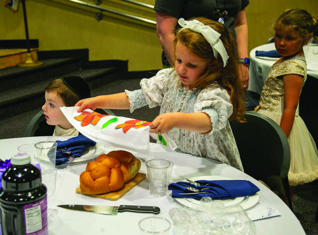 Suri Farkas helps set the Shabbat table.