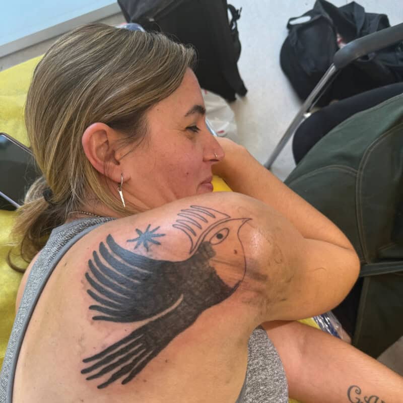 A woman with family still hostage in Gaza receives a dove tattoo.