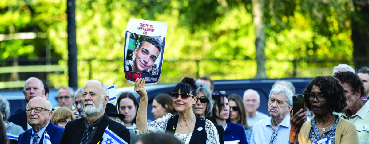 Cory Hill holds a poster of a hostage still captive in Gaza.