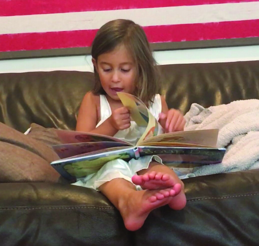 A young Kenna Werby embracing the joy of reading.