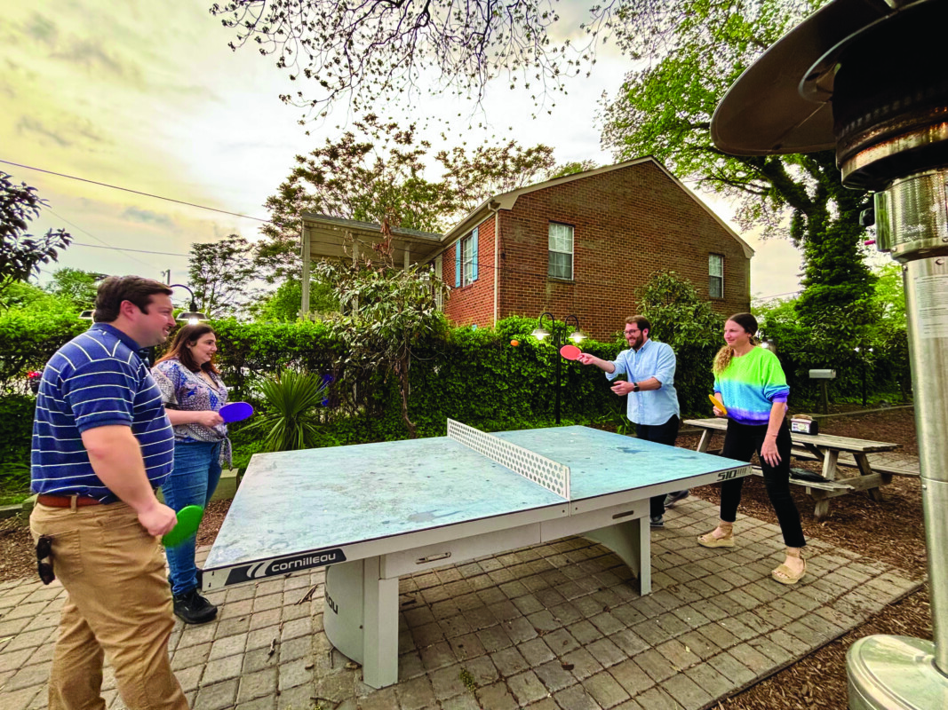 Fred Rose, Hilary Oser, Mark Gamsey, and Becca Barr enjoy a game of ping-pong.