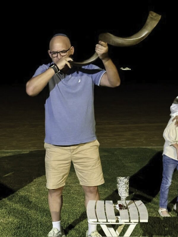 Rabbi Ari blows the shofar. 